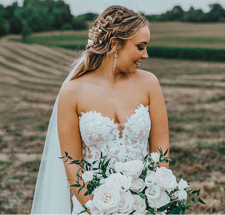 Bride holding a white bouquet outdoors